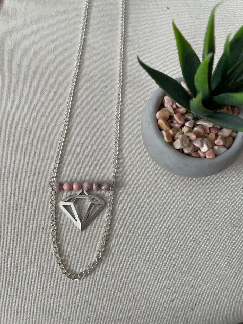 Pink turquoise round gemstone with silver coloured diamond pendant necklace
